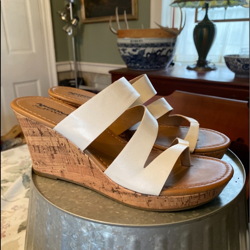 White sandals, cork wedge heel.